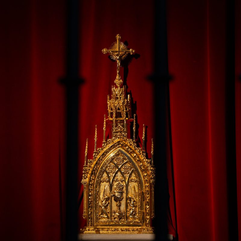 Tabernáculo dorado frente a una cortina roja